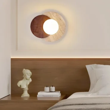 Kolvereid travertine wall light mounted above a bedside table in a bedroom