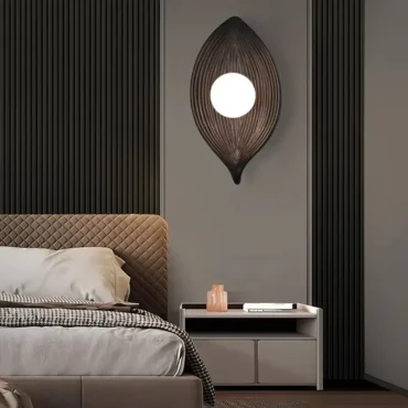 Voss leaf-shaped wall light mounted above a bedside table in a bedroom